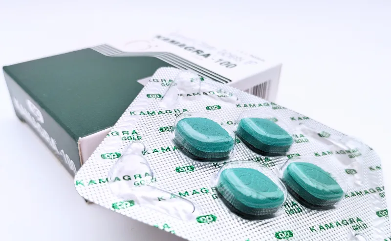 カマグラゴールド（KAMAGRA GOLD）100mgの箱と4錠が入ったシートを重ねて撮影した写真
